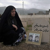 An Iraqi Kurdish woman sits near the tomb of a relative in Halabja this spring